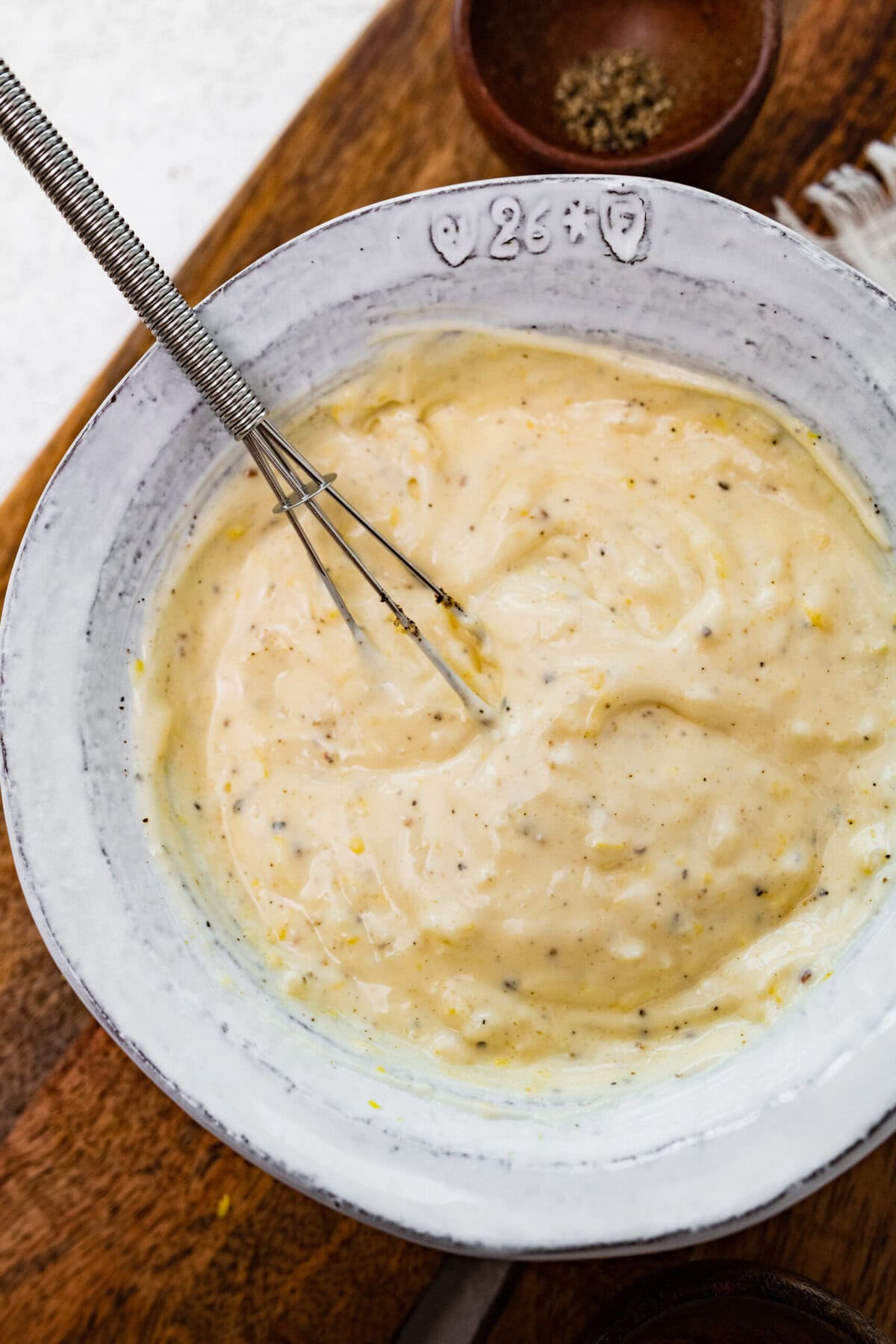 Lemon garlic aioli sauce dip in a bowl with whisk.