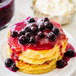 Pancakes with blueberry sauce on white plates