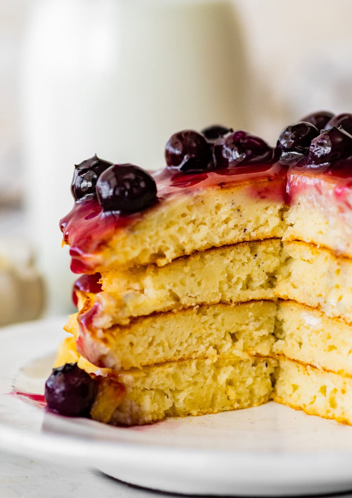 A stack of pancakes with blueberry sauce and a fork