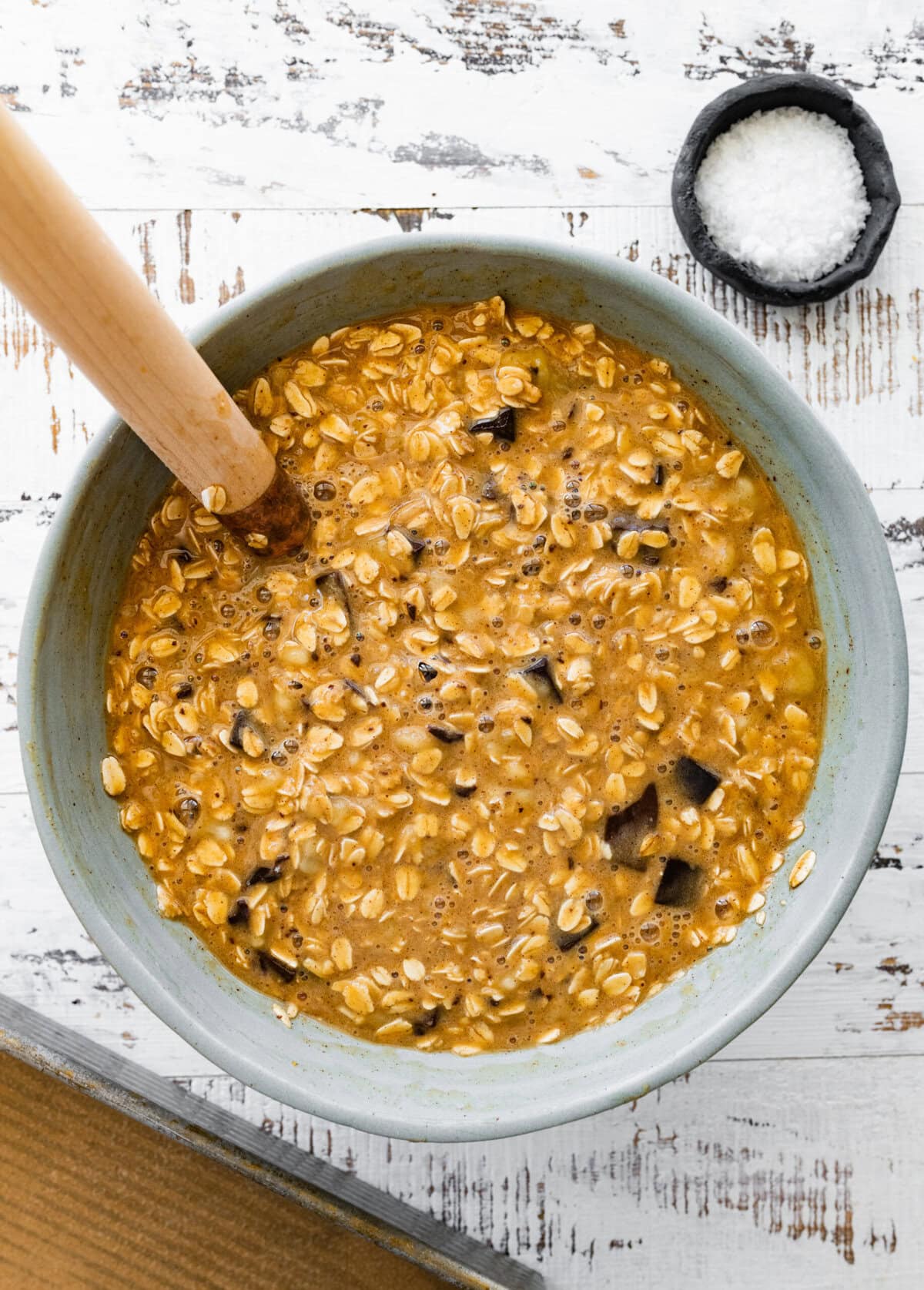 A bowl of oatmeal banana bars with a wooden spoon.