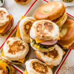 A tray of breakfast sandwiches with ham, cheese and eggs.