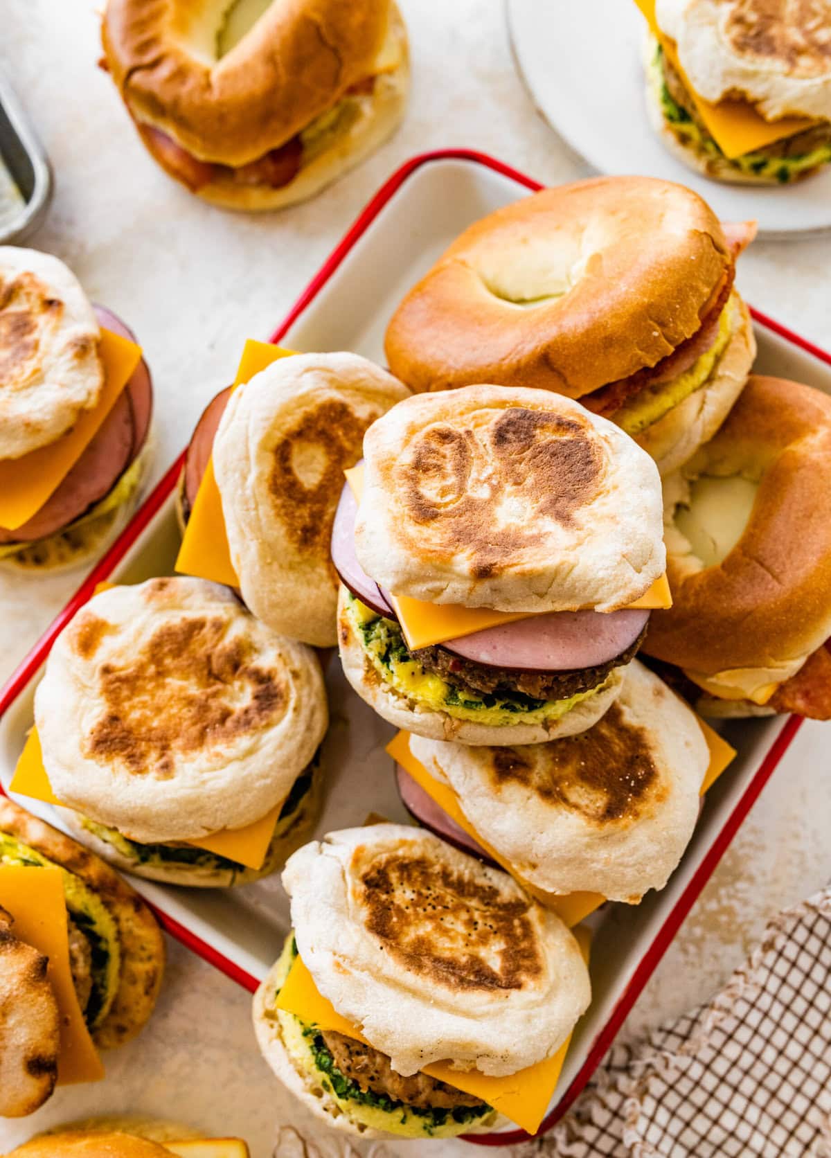A tray of breakfast sandwiches with ham, cheese and eggs.