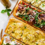 Three pizzas with different toppings on them.