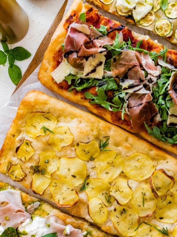 Three pizzas with different toppings on them.