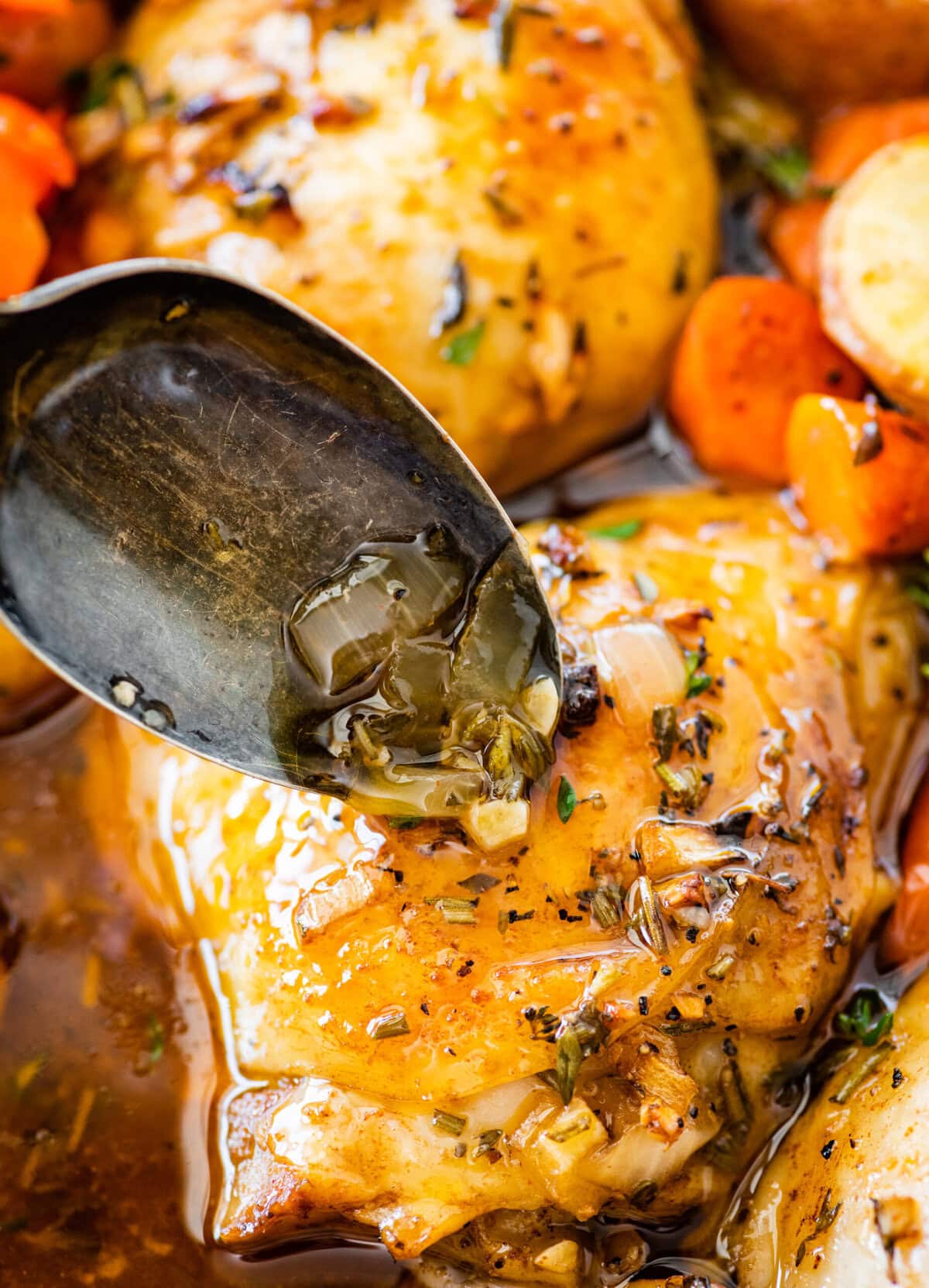 Spoon pouring sauce over potatoes.