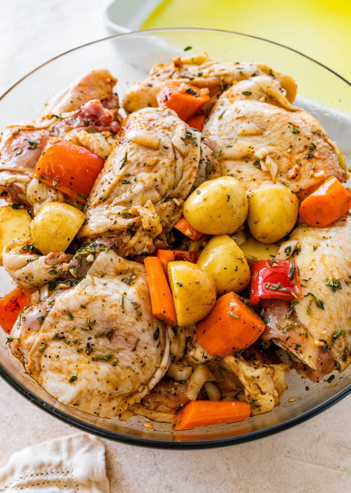 A bowl of chicken, potatoes, carrots and other vegetables.