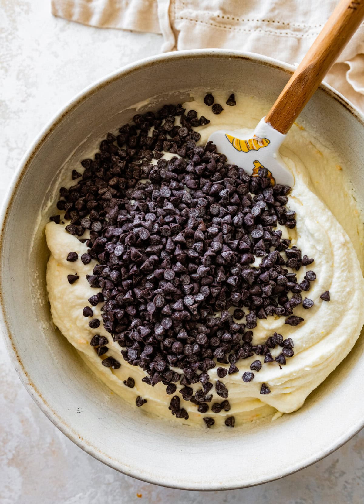 Chocolate chips in a bowl with cannoli frosting.