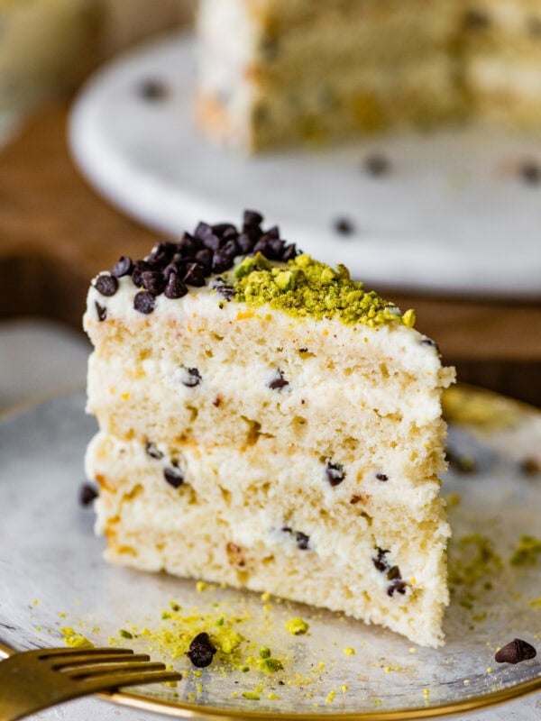 A slice of cannoli cake on a plate with a fork.