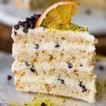 A slice of cannoli cake on a plate with a fork.