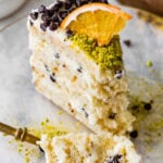 A slice of cannoli cake on a plate with a fork.