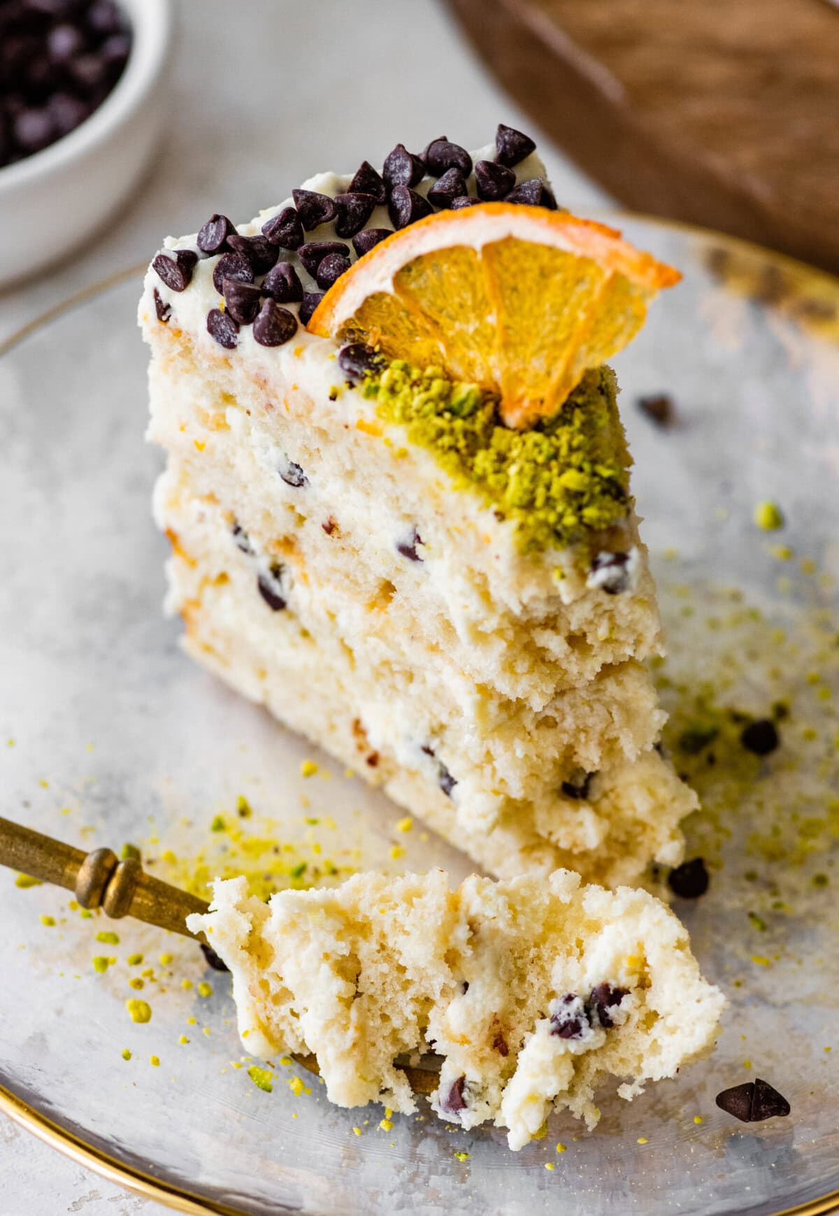 A slice of cannoli cake on a plate with a fork.