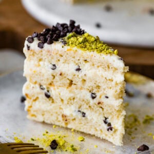 A slice of cannoli cake on a plate with a fork.