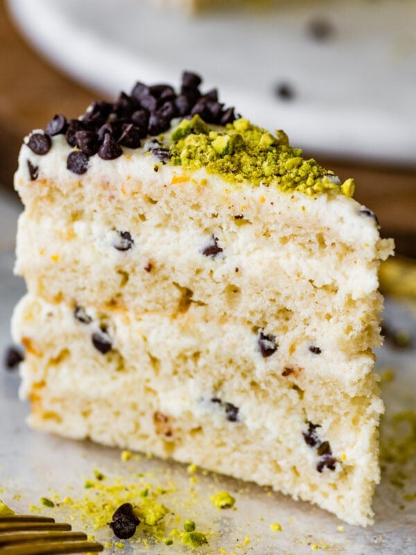 A slice of cannoli cake on a plate with a fork.