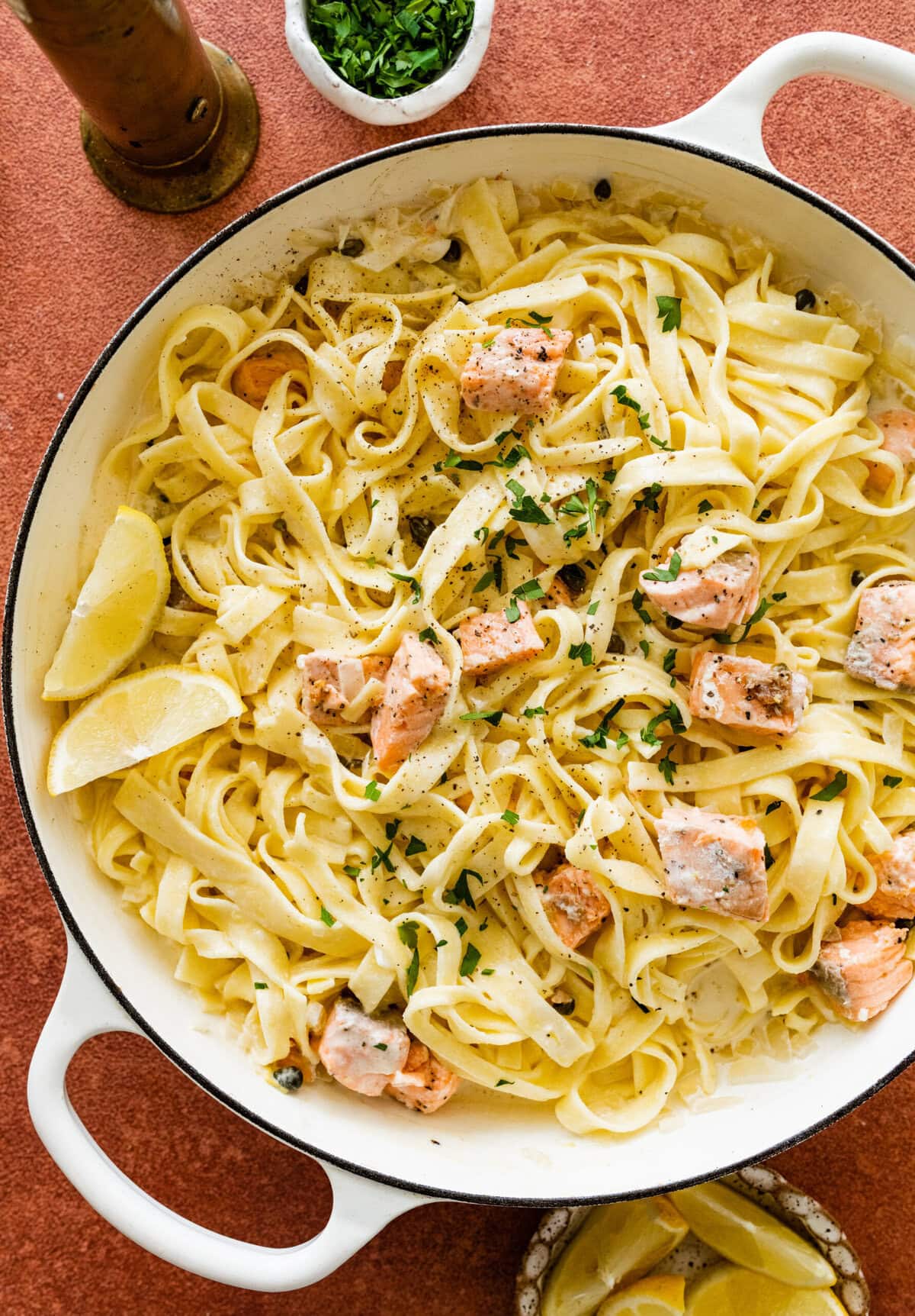 Pasta with salmon and lemon in a white pan.