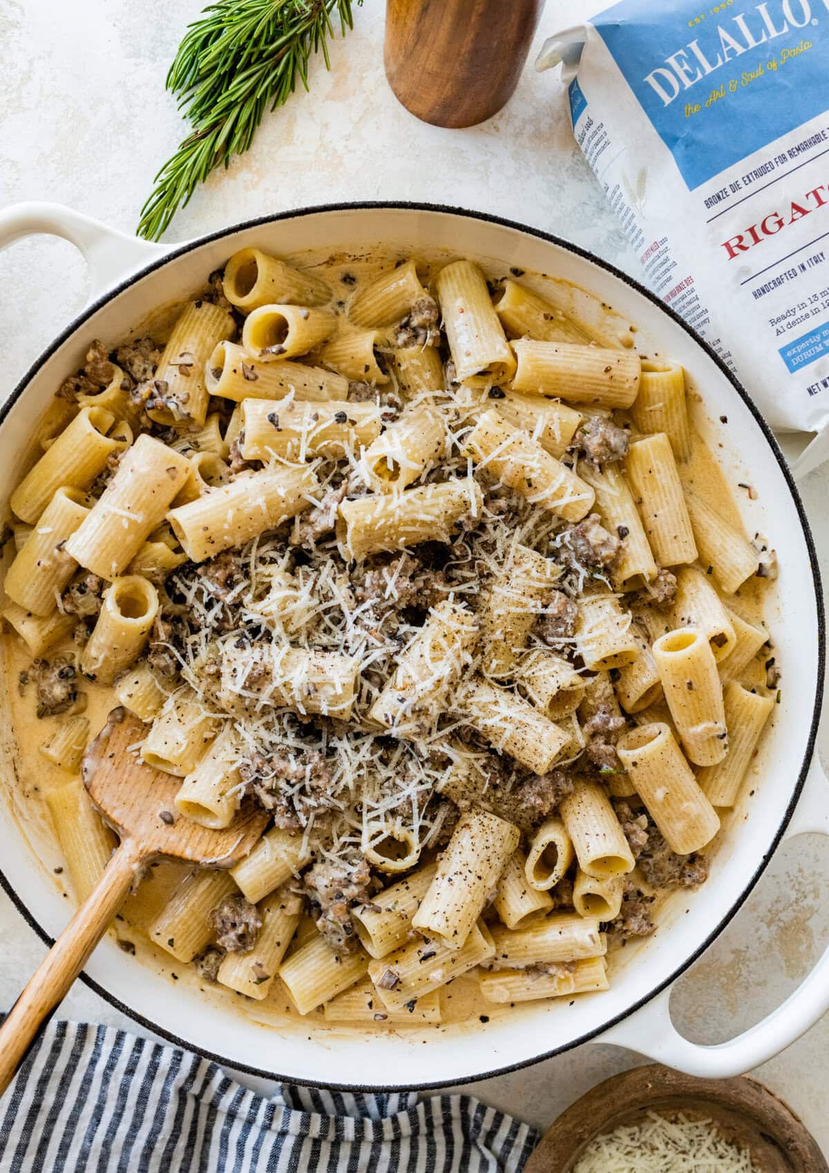 Pasta with Italian sausage and creamy sauce and cheese in a pan.