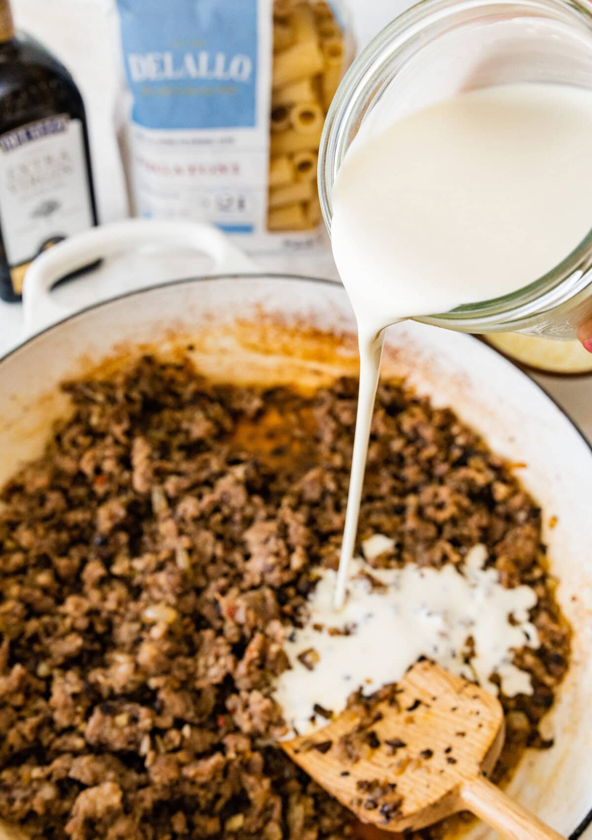 Pouring the cream sauce into the ground Italian sausage.