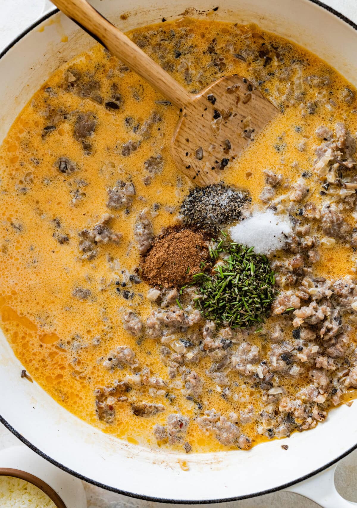 A skillet filled with creamy sausage sauce and spices.
