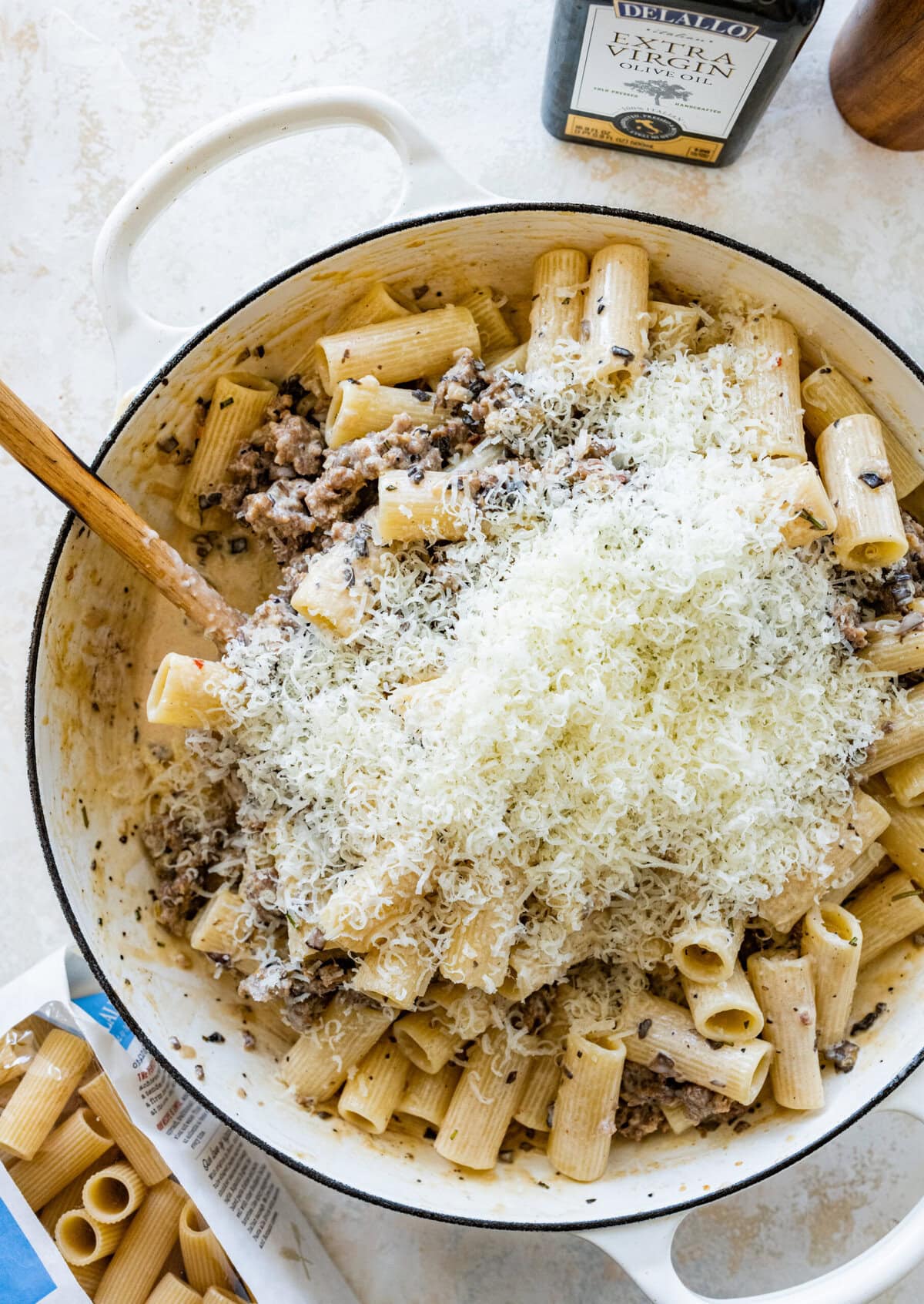 Pasta with Italian sausage and creamy sauce and cheese in a pan.