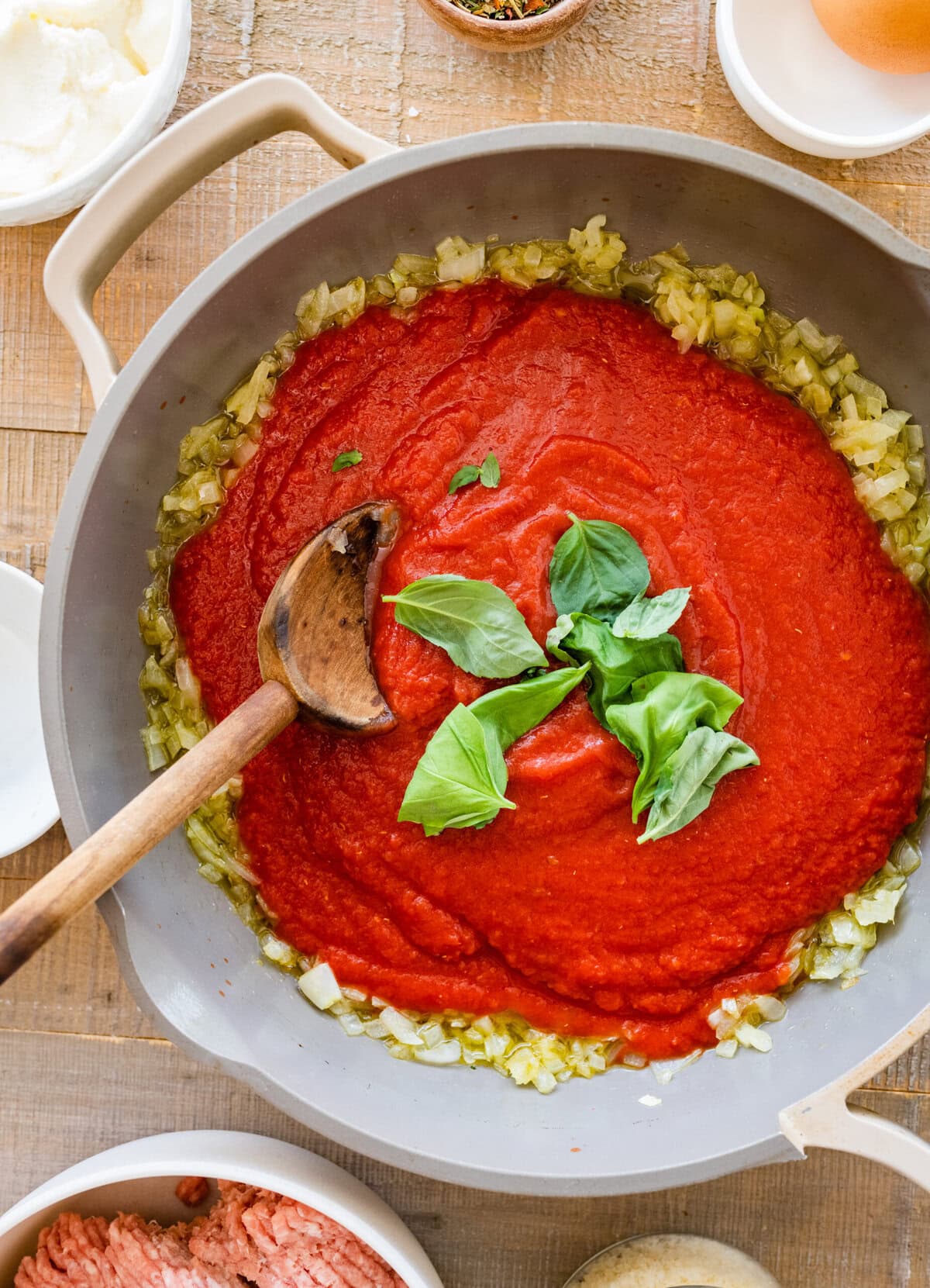 A pan filled with red tomaoto sauce and other ingredients.