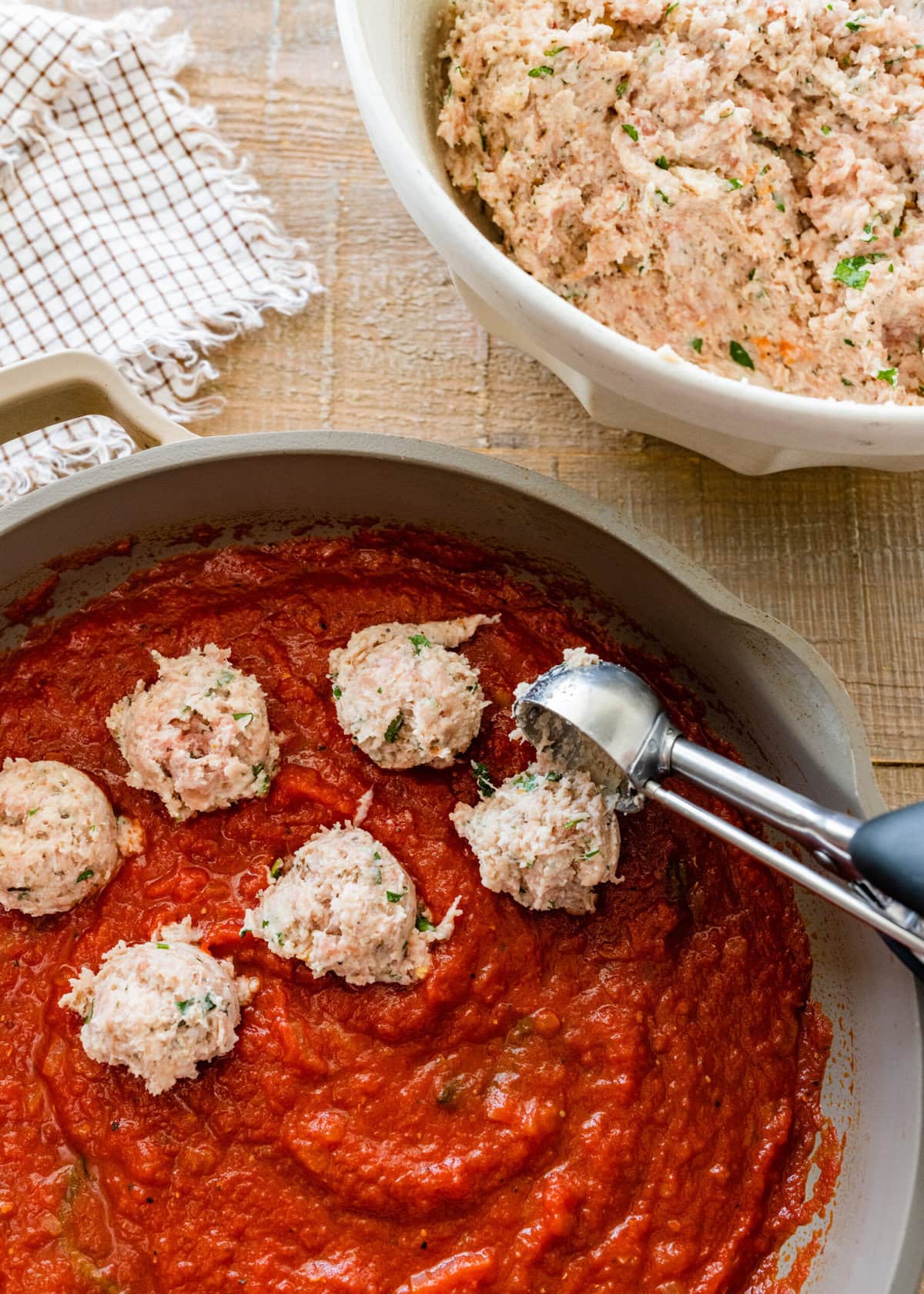 A pan with ricotta meatballs and sauce in it.