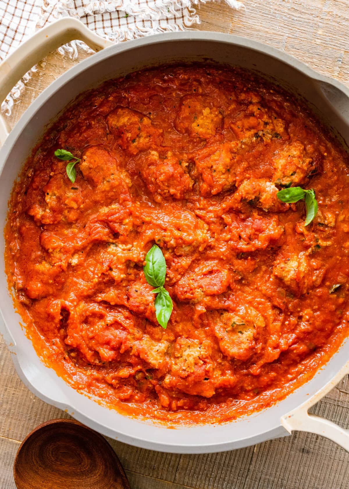 A pan filled with tomato sauce and ricotta turkey meatballs.