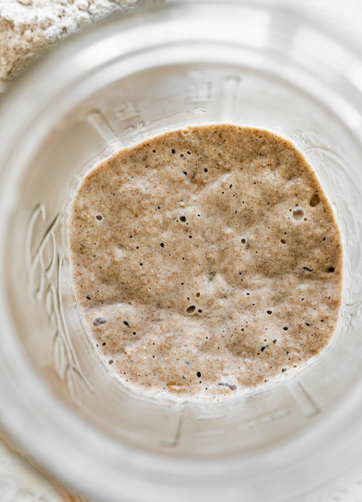 A mason jar filled with bubbly rye sourdough starter.