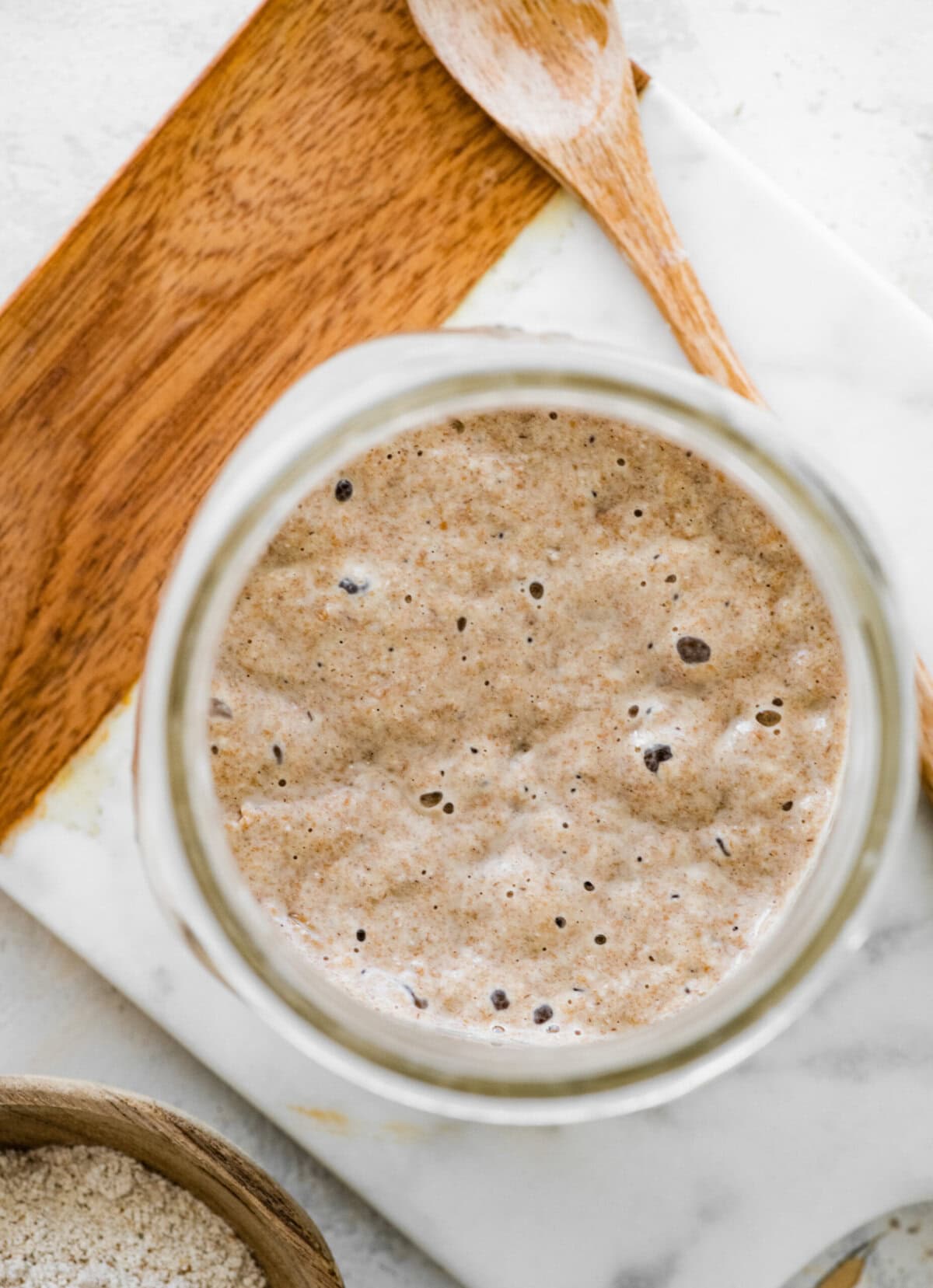 A mason jar filled with bubbly rye sourdough starter.