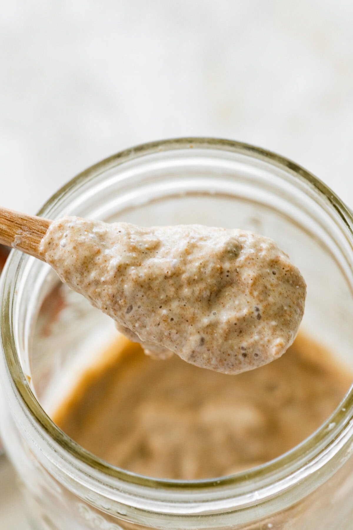 wooden spoon with bubble sourdough rye starter.