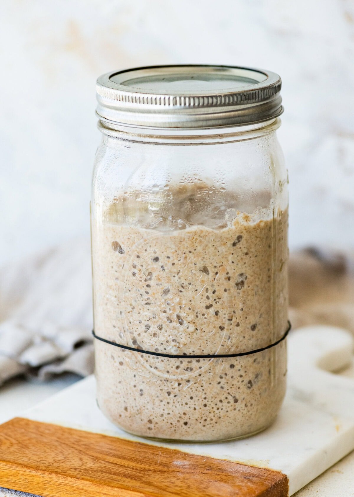 A mason jar filled with a homemade sourdough rye starter.