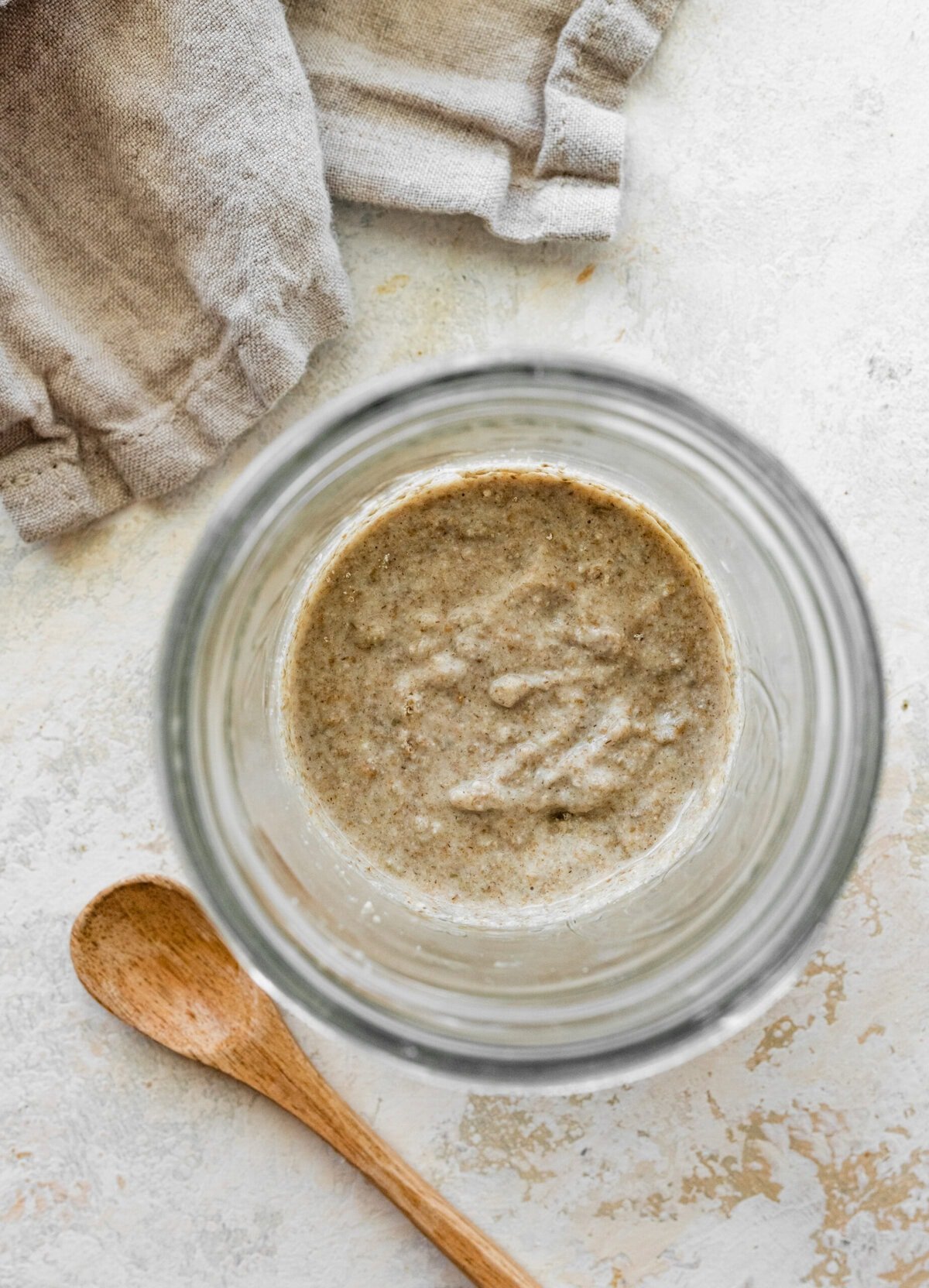 A mason jar filled with bubbly rye sourdough starter.