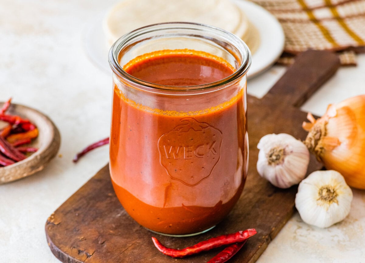 Homemade red enchilada sauce in a glass jar.