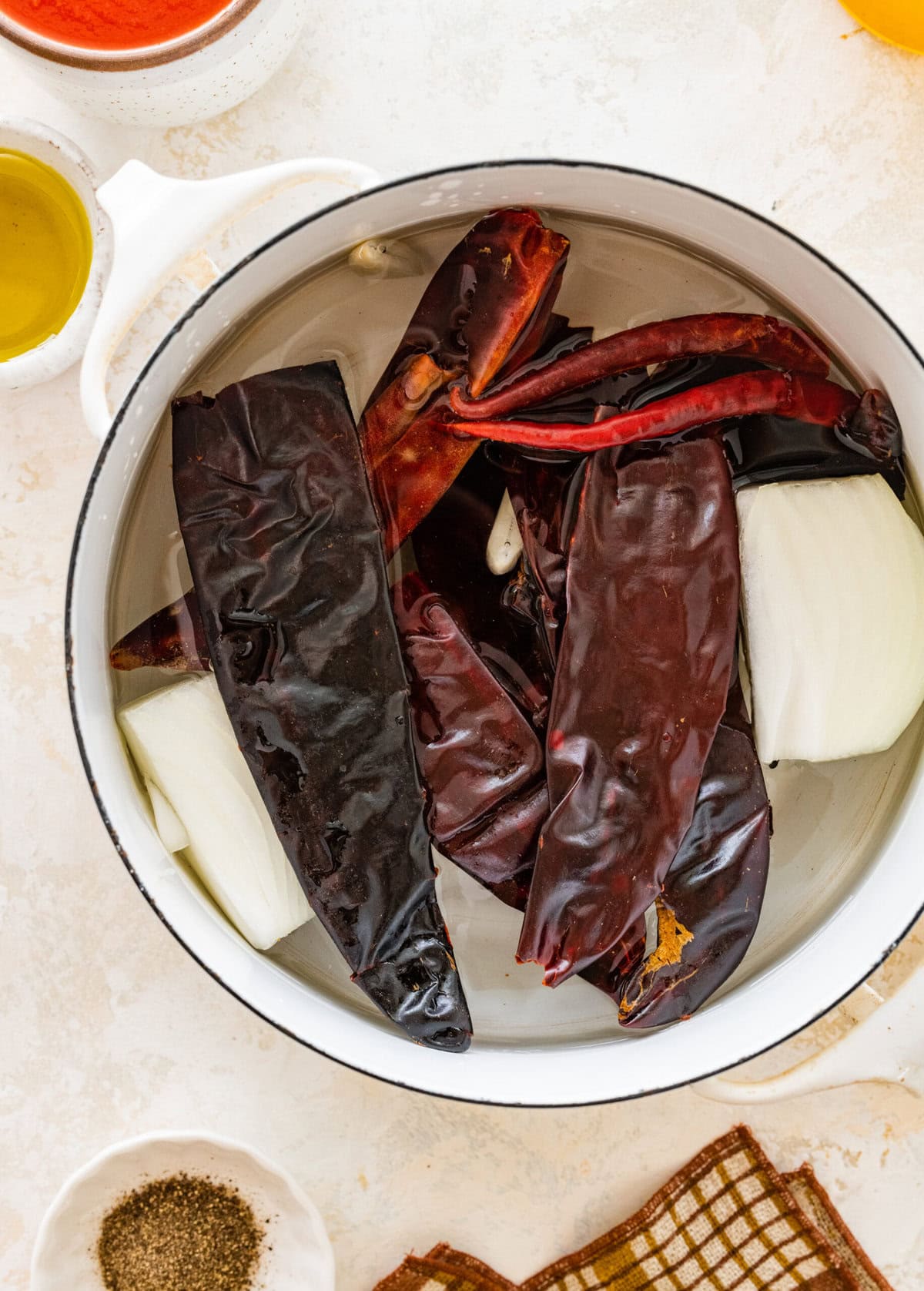 Chili peppers, garlic, and spices in a pot ready to boil.