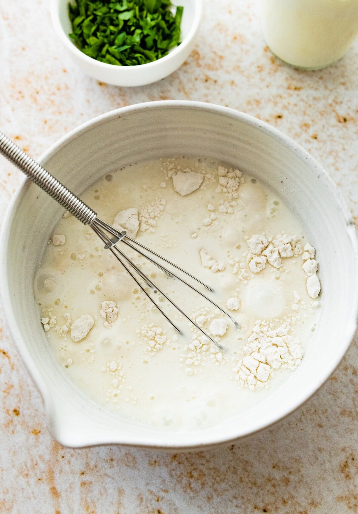 bowl with milk, cream, and flour, ready to add to the pan with cooked corn.