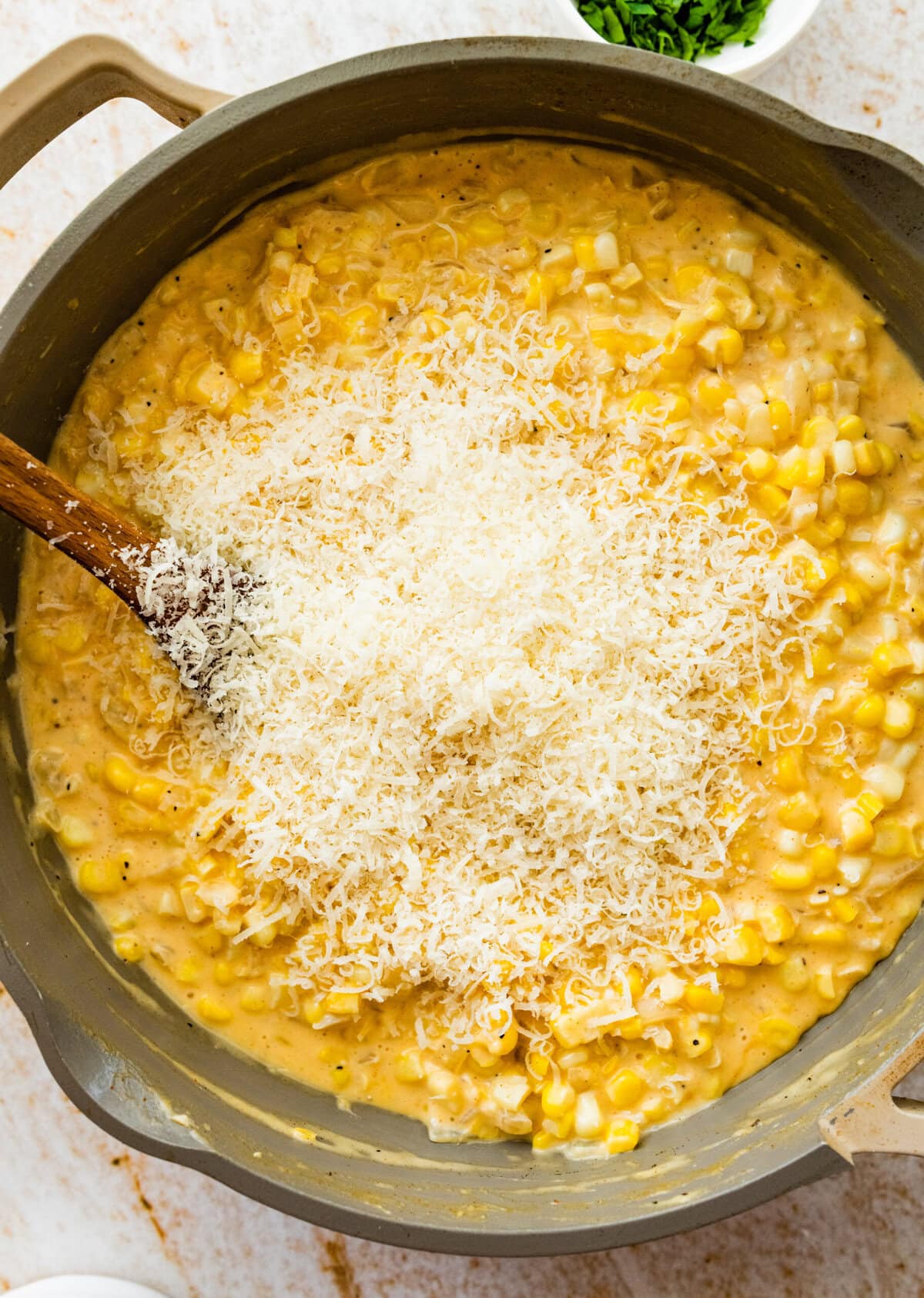 fresh parmesan cheese in the pan with thickeded cream corn.