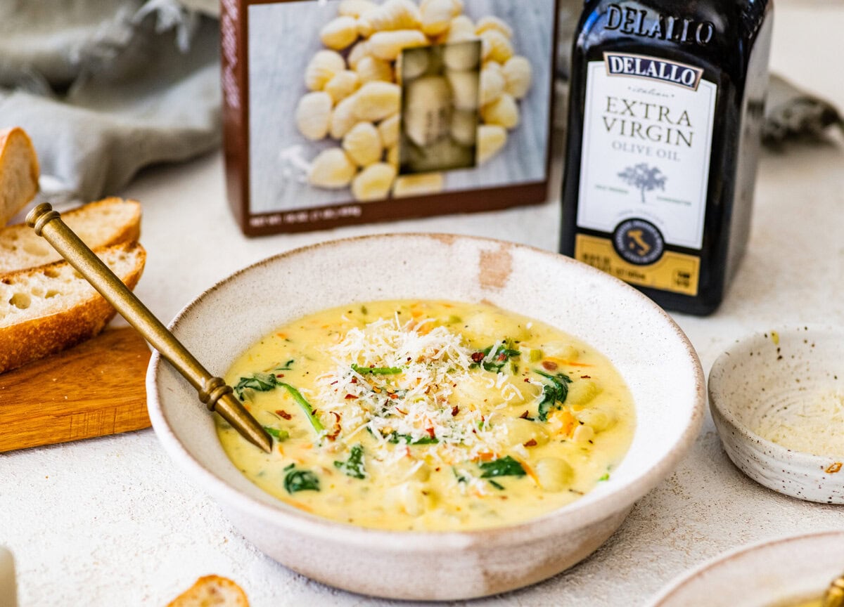 bowl of creamy gnocchi soup with a spoon in it.