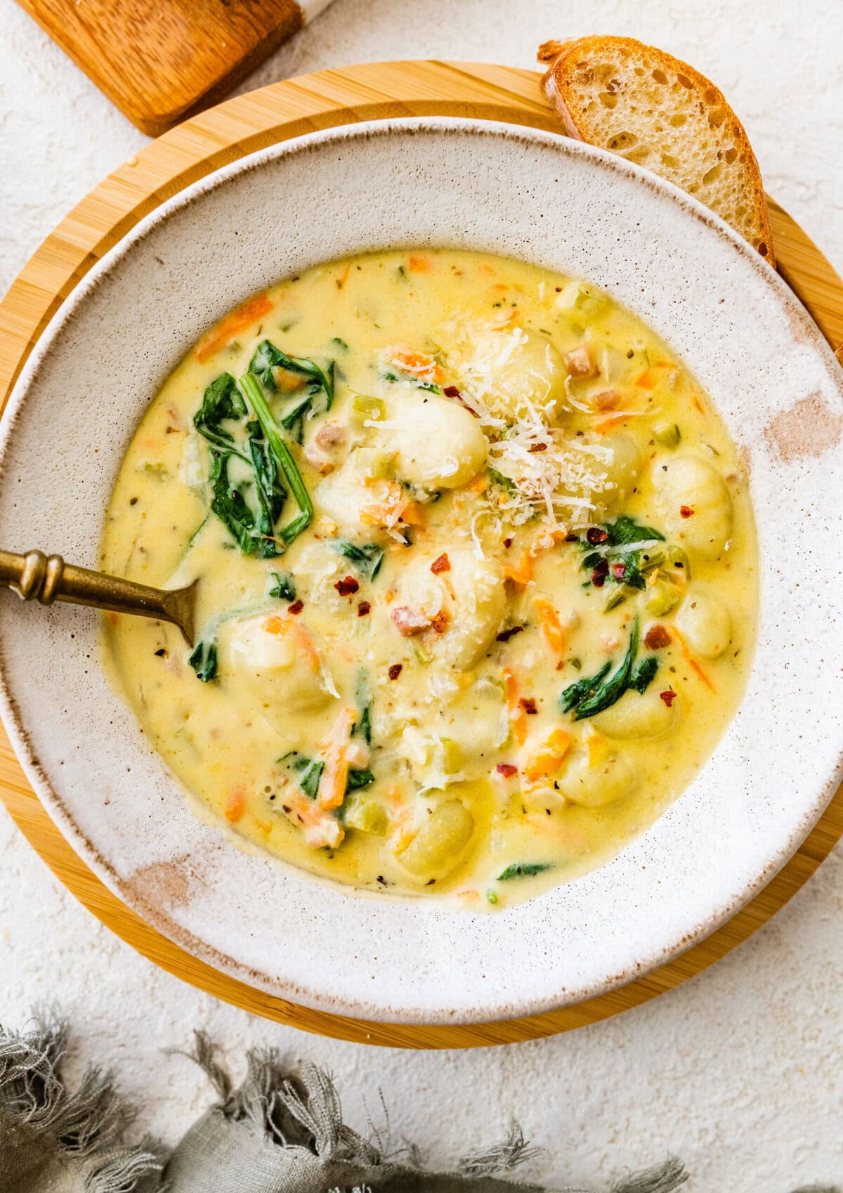 bowl of creamy gnocchi soup with a spoon in it.