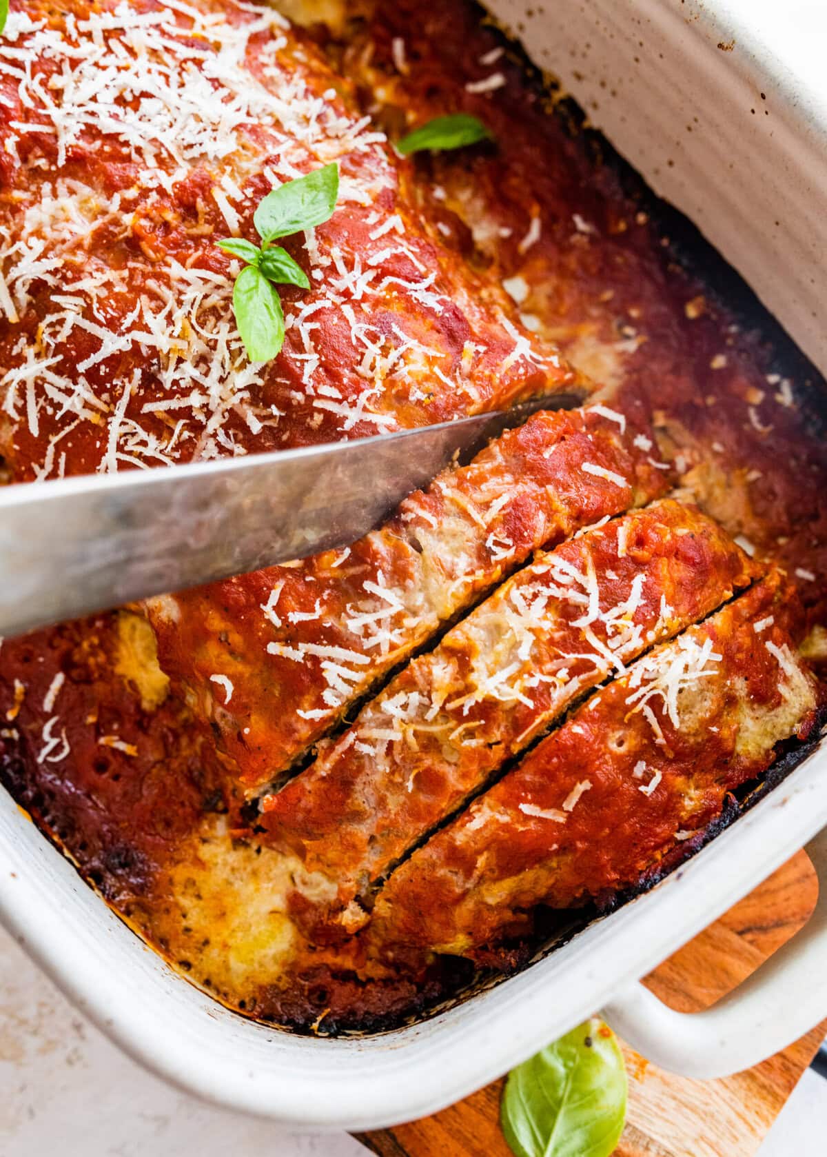 Cutting the meatloaf with a knife in the pan.