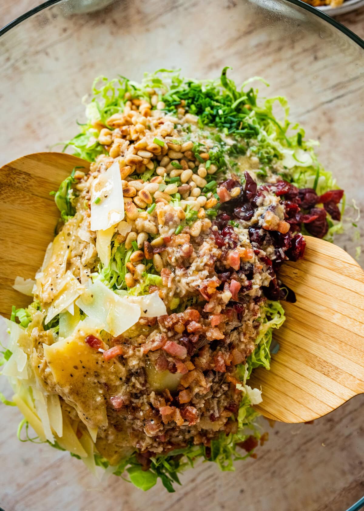 tossing all brussels sprouts salad ingredients in a large salad bowl.