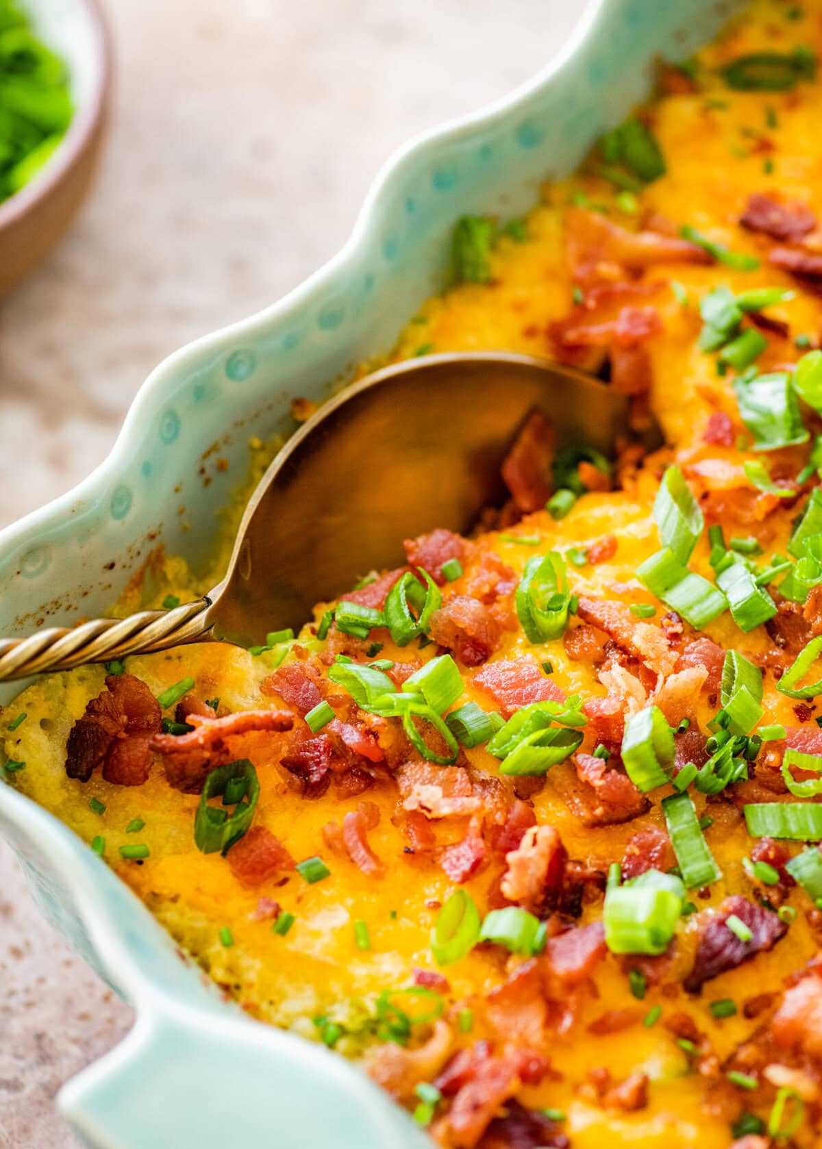 casserole of twice baked potato with a serving spoon in it.