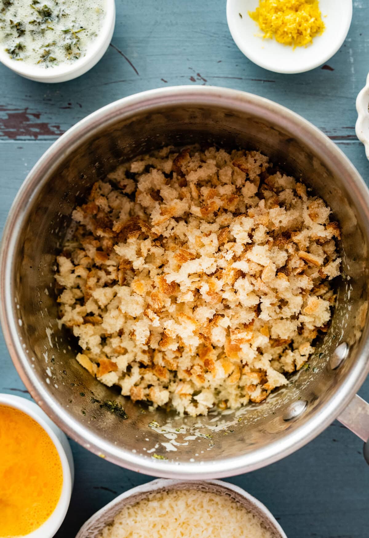 bread crumbs toasting in a pot with the herb butter.