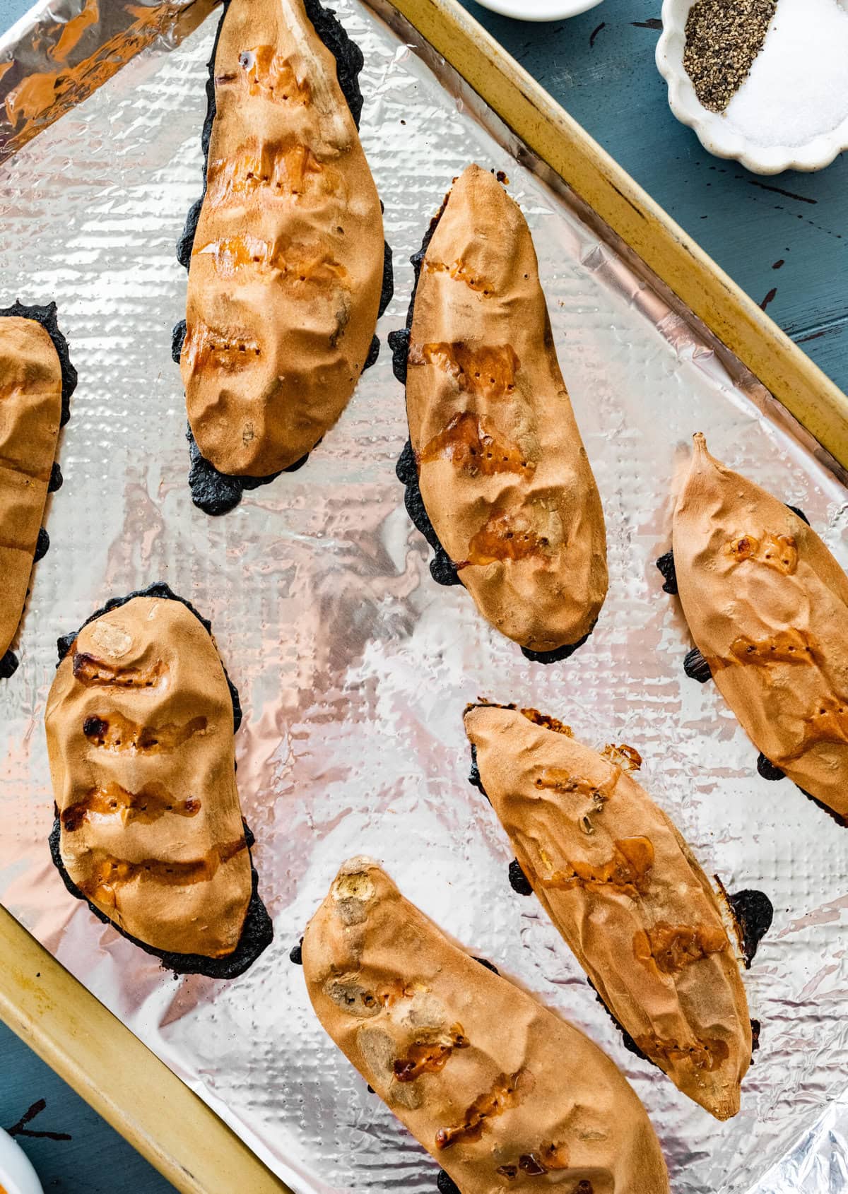 cooked sweet potato halves on a baking sheet after baking.