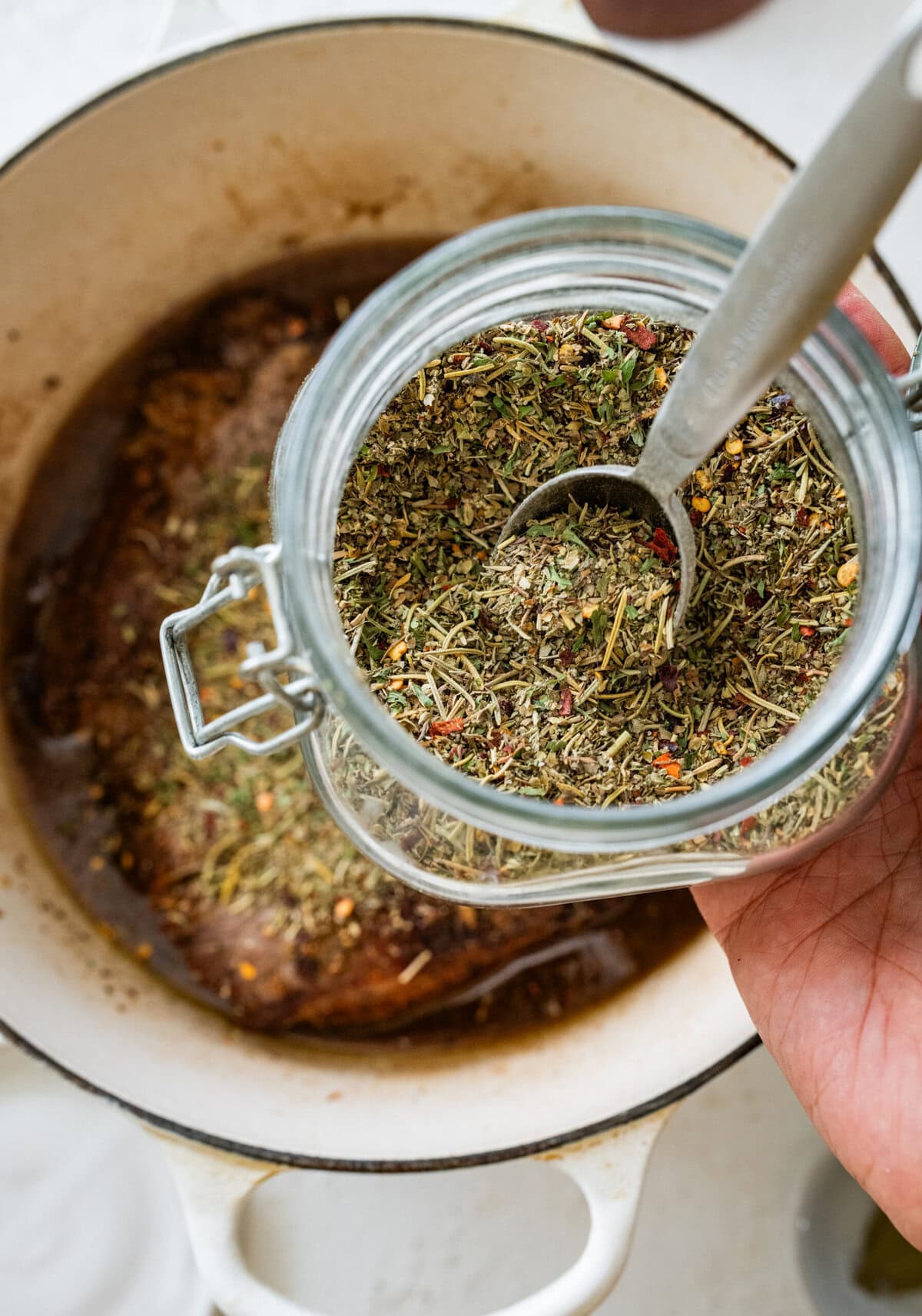 Add homemade Italian seasoning to the pot with meat.
