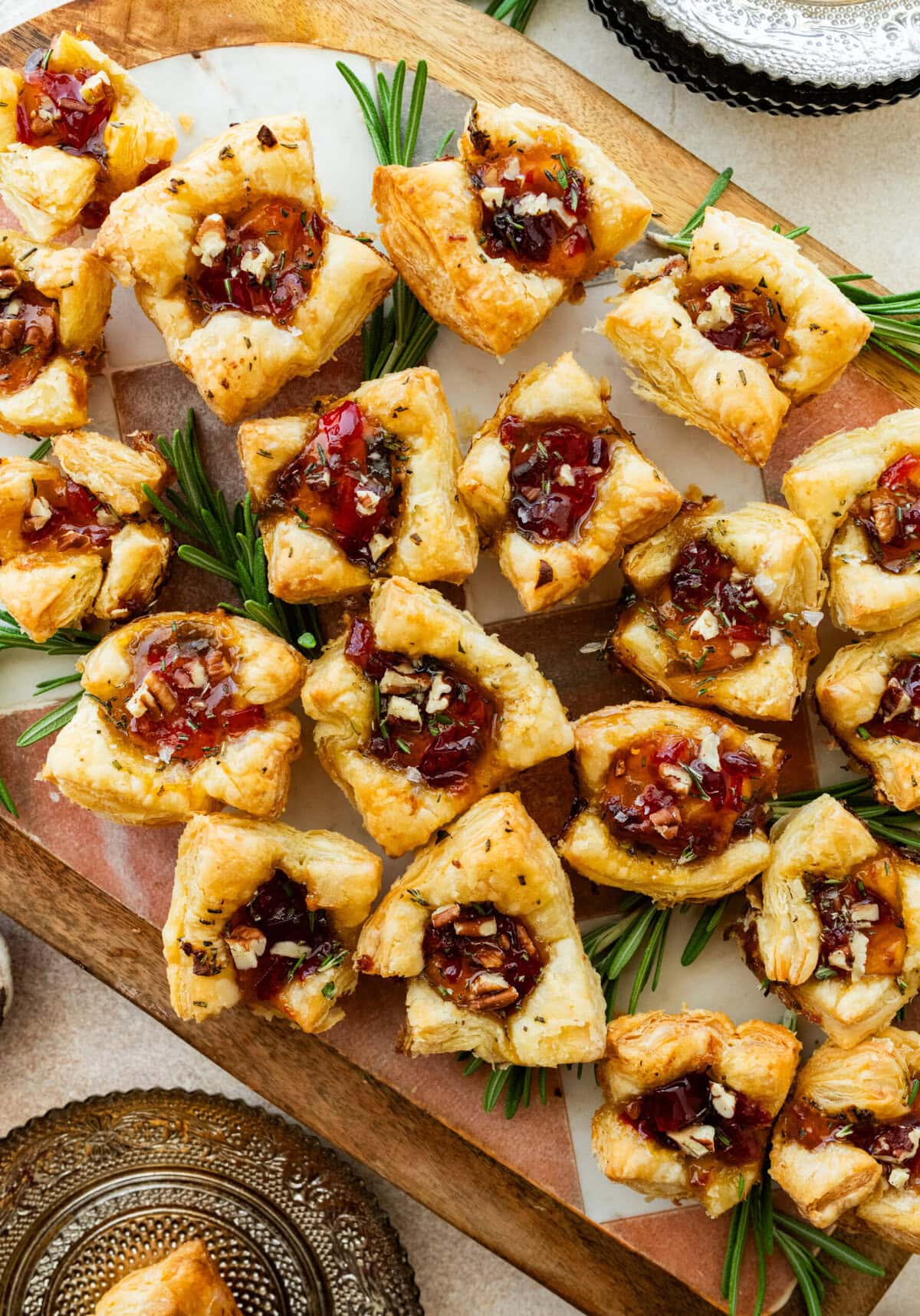 brie bites appetizer on a serving platter with herbs on the side.