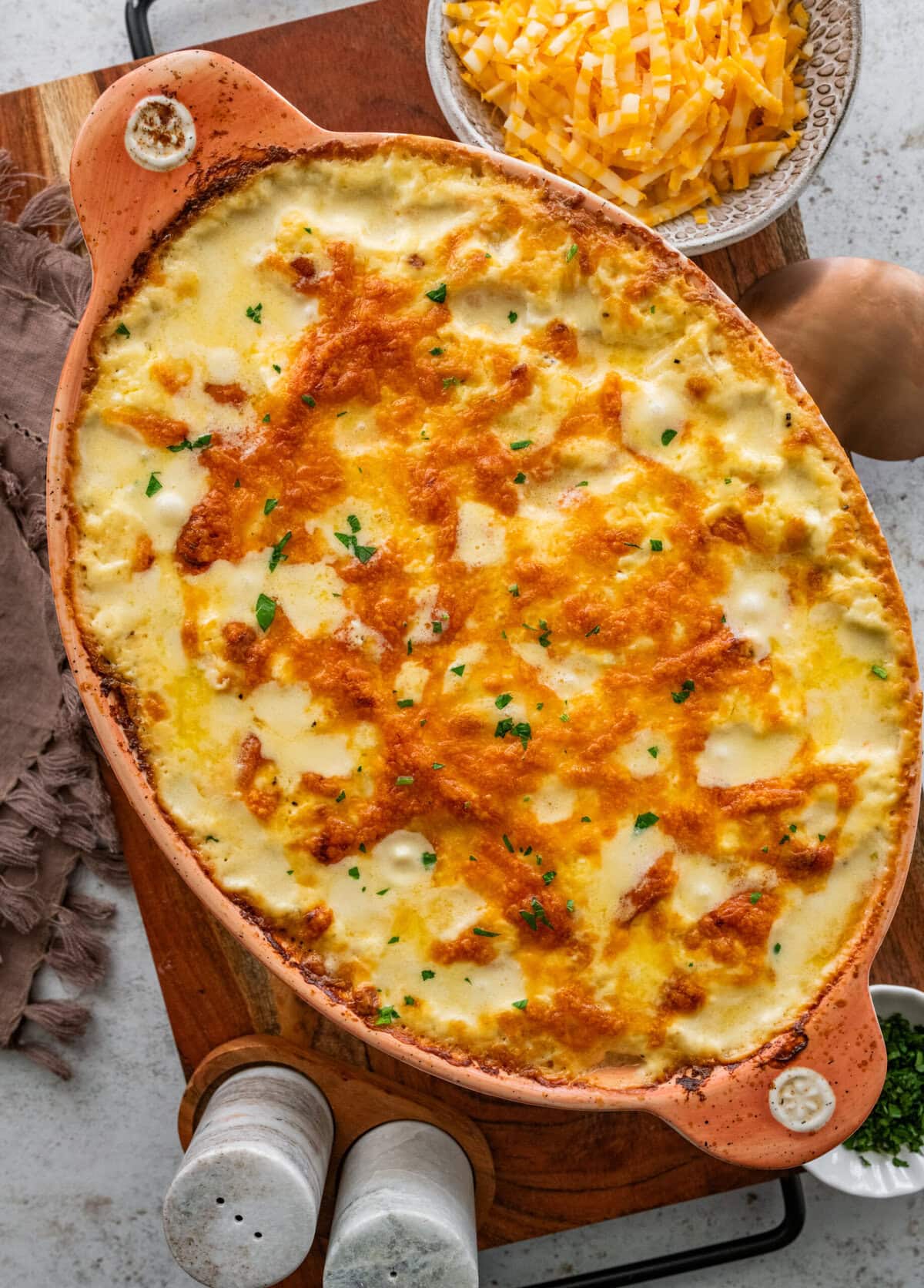 Easy cheesy potatoes in a casserole dish with golden brown bubbly top.