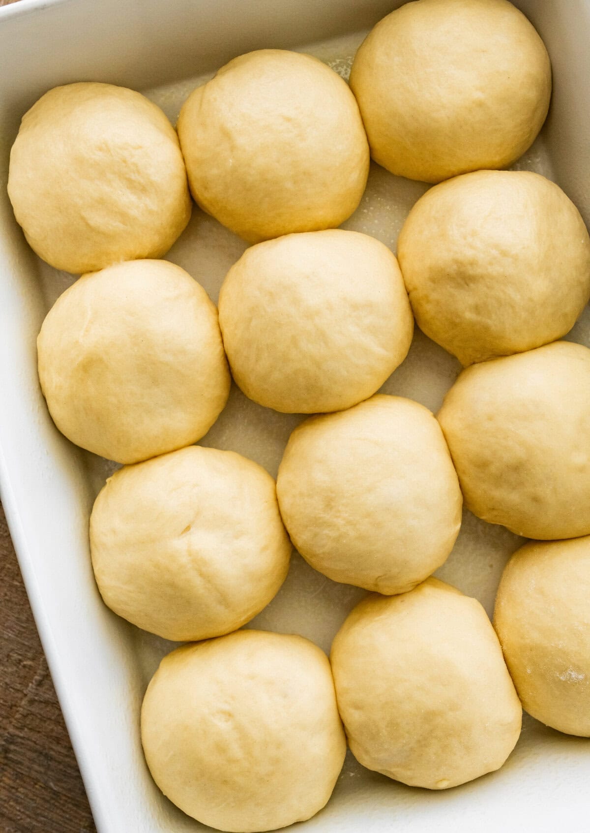 12 easy homemade dinner rolls in a baking dish before rising for second time.