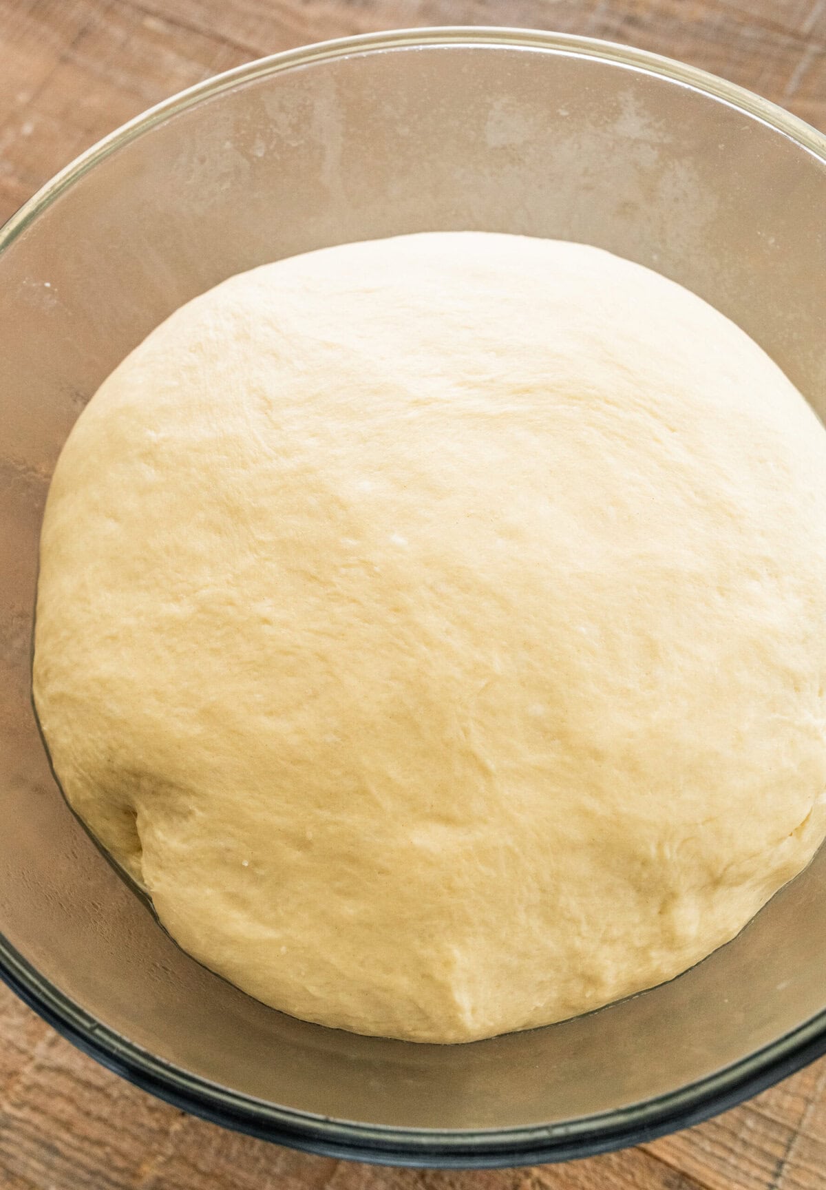 bread dough for easy homemade rolls on a wooden cutting board after rising at room temp.