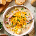 ham and potato soup in a soup bowl with cheese and chives on top. Spoon in bowl.