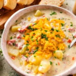 ham and potato soup in a soup bowl with cheese and chives on top. Spoon in bowl.