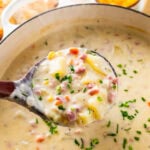 ham and potato soup in a pot with a wooden ladle in it.