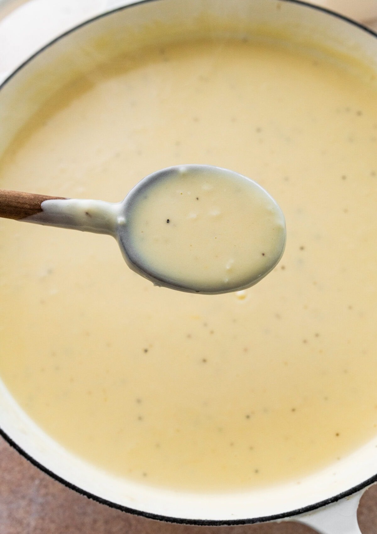 spoon holding up some of the cheesy sauce forthe homemade mac and cheese.